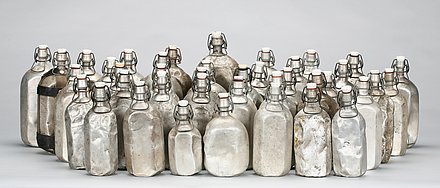 Eine Sammlung von Weißblech-Trinkflaschen in verschiedenen Größen, die durch den täglichen Gebrauch gekennzeichnet sind. 