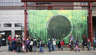 Eine Schulklasse draußen vor dem Ruhr Museum laufen mit ihren Lehrer*innen in Richtung Kohlenwäsche.