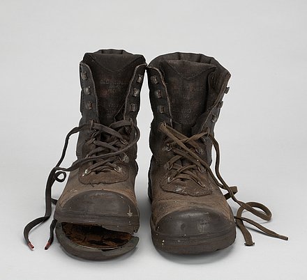 Photograph of worn boots with laces.