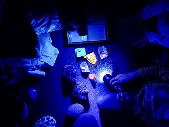 leuchtende Steine unter einer Taschenlampe