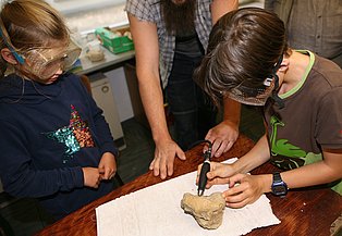 Kinder beim Workshop Fossilien fälschen.