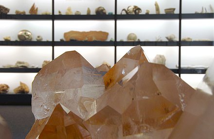 Nahaufnahme eines Kristalls vor anderen Exponaten des Mineralien-Museums.