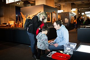 Besucher*innen mit Kind lösen Aufgaben im Ruhr Museum.