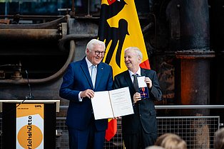Foto zeigt den Bundespräsident der Bundesrepublik Deutschland, Frank-Walter Steinmeier, mit der Urkunde in der Hand und Prof. Heinrich Theodor Grütter mit dem Bundesverdienstkreuz in der Hand bei der Verleihung eben dieser in Hattingen am 24.9.2026.