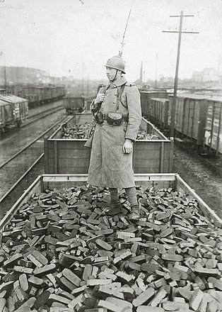 Ein französischer Soldat bewacht einen mit Kohlebriketts beladenen Güterzug, Ende Januar 1923.