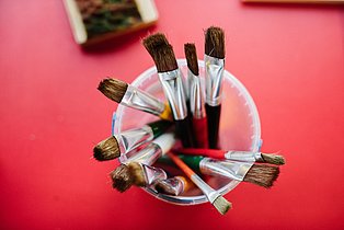 Workshop Färberpflanzen  Nahaufnahme aus der Vogelperspektive von einem Glas mit verschiedenen Pinseln.