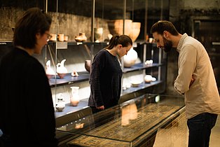 Besucher*innen betrachten Exponate in der Dauerausstellung.