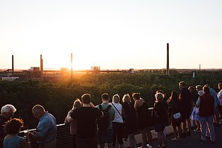 Kohlenwäsche und Kohle Lounge im Rahmen der Extraschicht 2018  Menschenansammlung betrachtet den Sonnenuntergang auf dem Gelände von Zollverein.