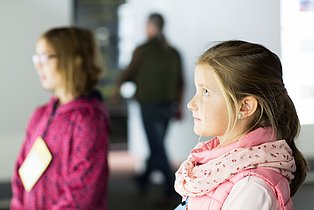 Zwei Kinder, im Profil aufgenommen, betrachten etwas in der Dauerausstellung.
