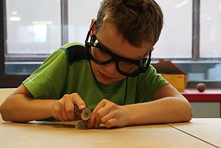 Ruhr Museum Kinder Workshop  Ein Kind während der Bearbeitung eines Steines.