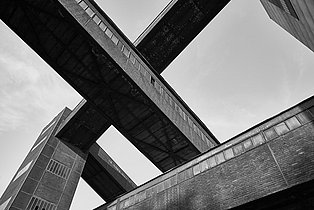 Bandbrücken an der Kohlenwäsche, 2006 Schwarz-Weiß-Foto mit dem Blick nach oben auf mehrere sich kreuzender Bandbrücken auf dem UNESCO-Welterbe Zollverein