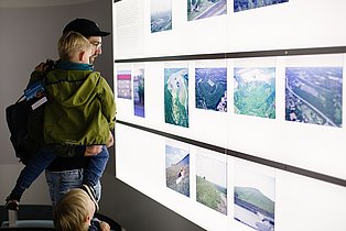 Zwei Kinder und ein Erwachsener betrachten eine Leuchttafel in der Dauerausstellung des Ruhr Museums.